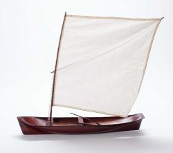 Embarcação com casco raso; proa delgada e popa achatada; mastro único com vela latina quadrangular e com dois remos com pás em forma de pena.